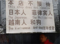 Вывеска, сообщающая о том, что ресторан не обслуживает клиентов из Вьетнама, Японии, Филиппин, а также собак. Фото:Mark Ralston / AFP